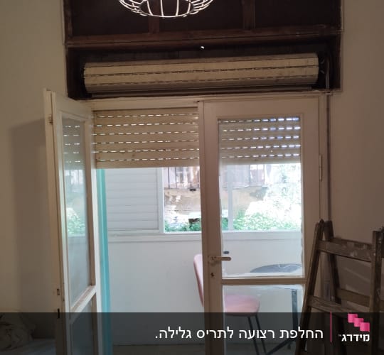 תריס גלילה פתוח למחצה מעל דלת זכוכית